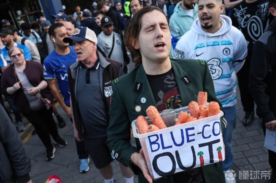 切尔西球迷手持胡萝卜抗议BlueCo，它象征着“空头支票”